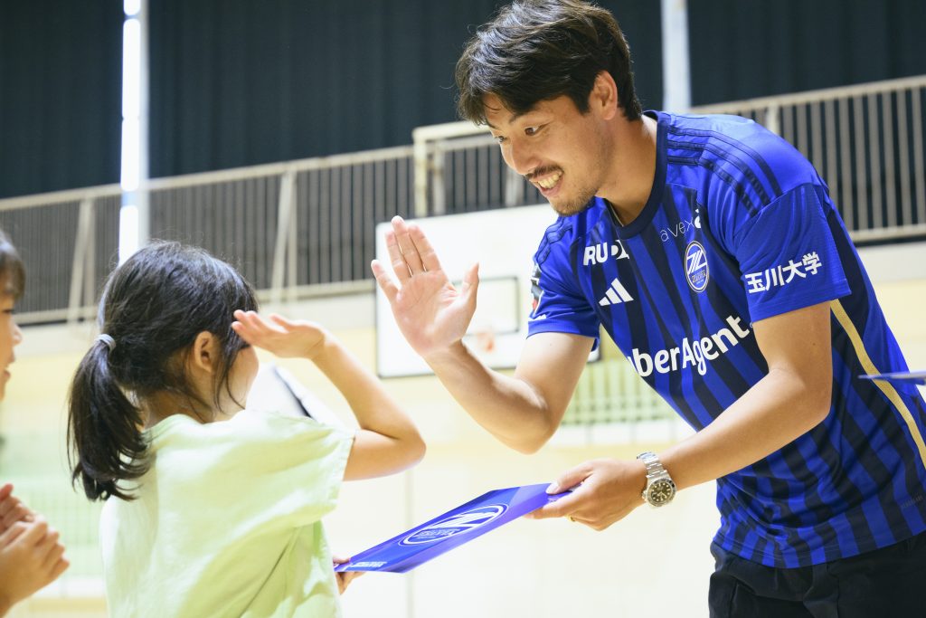 町田市立大蔵小学校の１年生に下敷きをプレゼントする昌子源選手